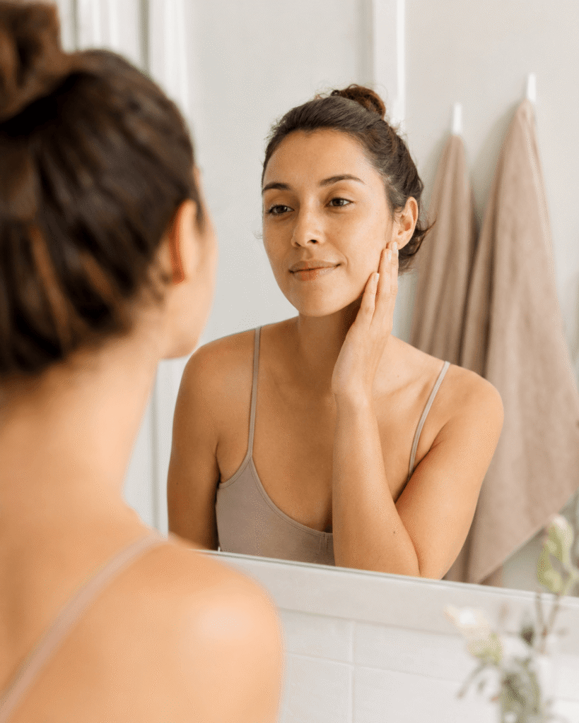 Woman checking her skin in the mirror after washing her face